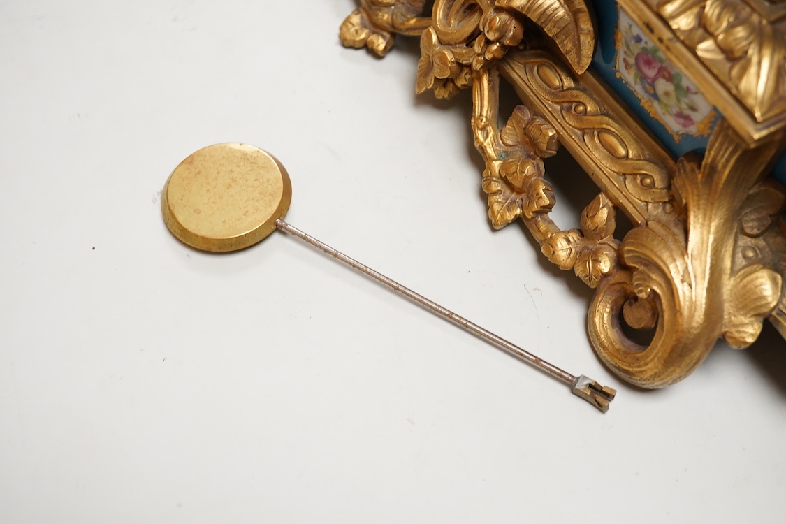 A Louis XV style figural brass mantel clock striking on a bell, with enamel dial and inset plaques, surmounted with two figures, with pendulum, no key, 42cm wide